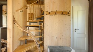 A wooden interior with a spiral staircase, a coat rack, and a door. - Holiday Home 'Ferienhaus Alpenzauber' with Mountain View, Private Terrace and Wi-Fi (Lennestadt)