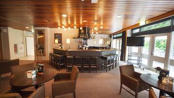 Enjoy a drink at the central bar, surrounded by comfortable seating and a flat-screen TV.