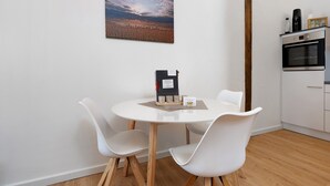 Una cocina moderna con armarios blancos, un horno empotrado y una viga de techo de madera.