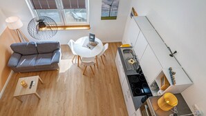 Un espace de vie compact comprenant un canapé, une table à manger et une kitchenette.
