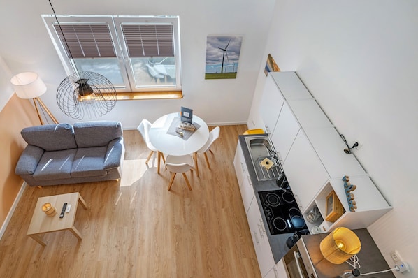 A compact living space with a sofa, dining table, and kitchenette.