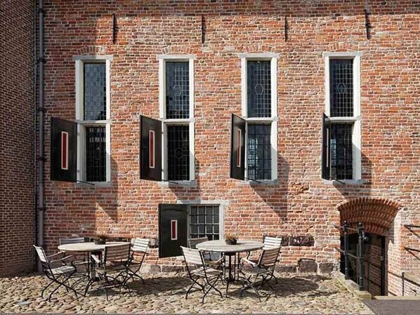 Traditional brick building with classic windows and a charming outdoor seating area.