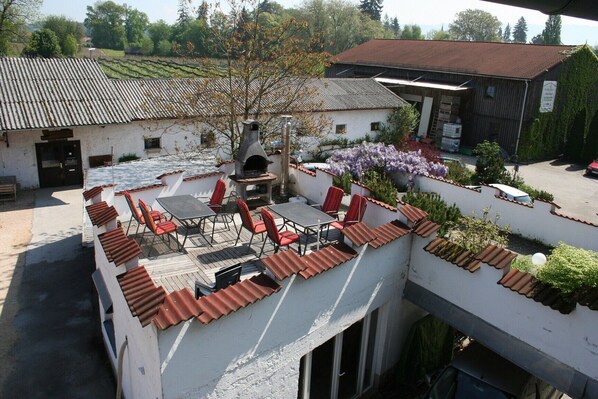 A rooftop patio with outdoor seating and a wood-fired oven.