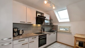 A modern kitchen with a built-in oven, microwave, and coffee maker.
