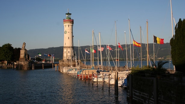 A lighthouse, a dock with boats, and flags. - Apartment '1' with Shared Terrace, Shared Garden and Wi-Fi (Lindau am Bodensee)