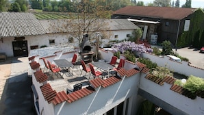 A rooftop patio with outdoor seating and a wood-fired oven. - Apartment '1' with Shared Terrace, Shared Garden and Wi-Fi (Lindau am Bodensee)
