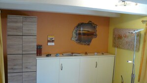 A room with a white wardrobe, a black chair, a desk with a Rubik's cube, a clock, and a wall with a decorative piece. - Holiday Apartment '19sqm' with Wi-Fi in Quiet St. Georgen Backyard (Freiburg)