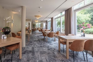 Enjoy meals in our elegant dining area with long tables and comfortable seating.
