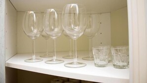 Una estantería con varias copas de vino y algunas copas más pequeñas.