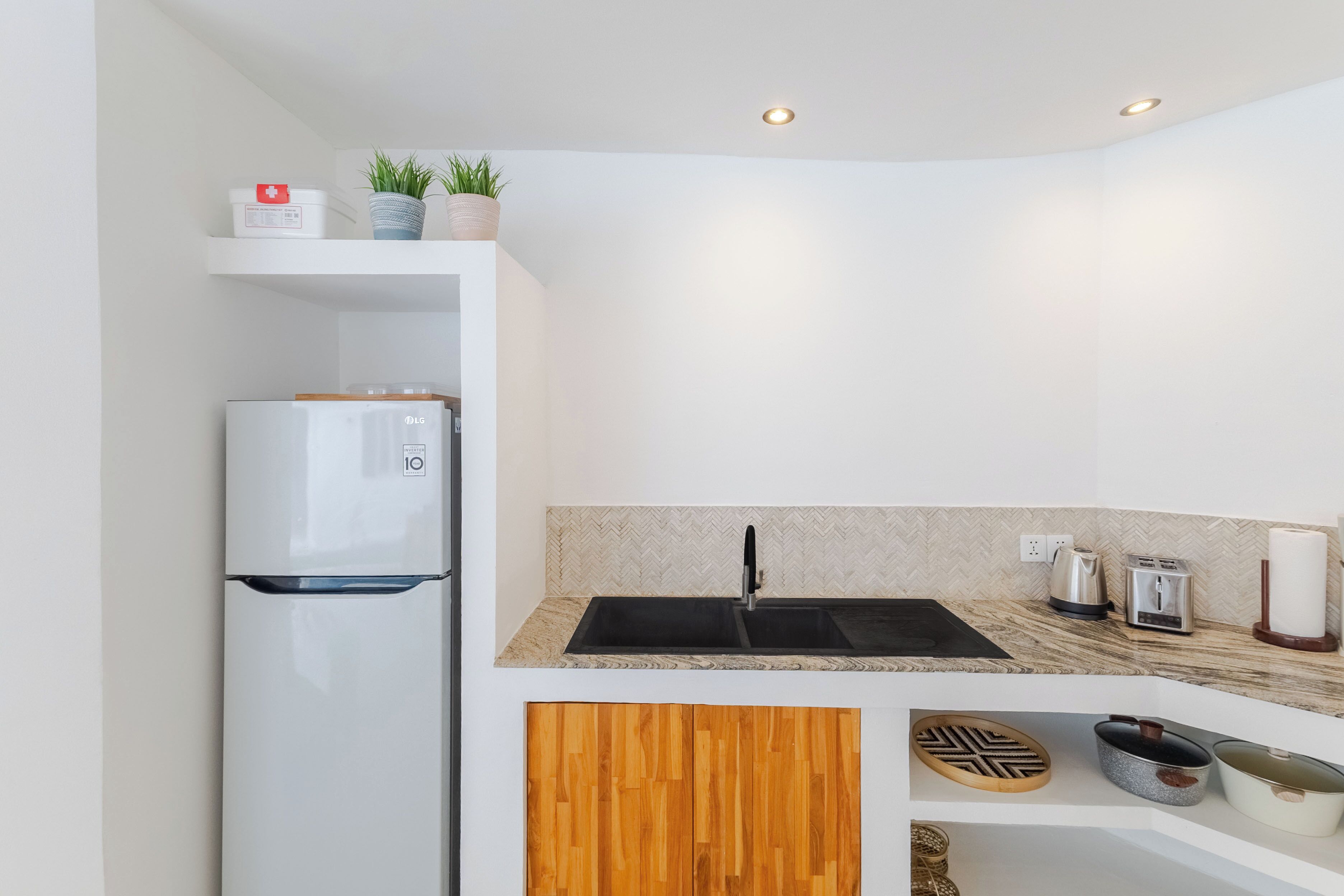 A compact kitchen with a refrigerator, sink, and countertop appliances.