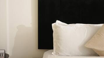 Un dormitorio con cama, mesita de noche y un cuadro enmarcado en la pared.