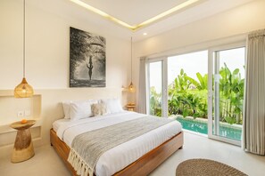 A modern bedroom with a large bed, a painting, and a view of a swimming pool. - 2BR Tropical Villa with Rooftop & Private Pool (cemagi)