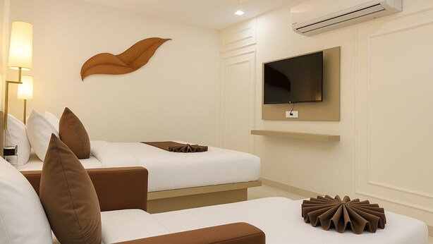 Ein Hotelzimmer mit zwei Betten, einem an der Wand montierten Fernseher und einer modernen Lampe.