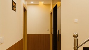 Ein moderner Flur mit Holzvertäfelung, einem Schild mit der Aufschrift 'whit zone' und einer Treppe mit Metallgeländer.