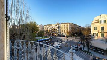 Una strada cittadina con edifici, un autobus e automobili.