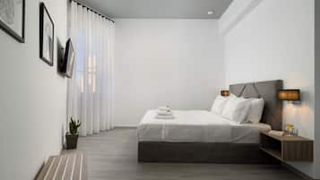 Una camera da letto moderna con un letto, un comodino, una lampada e una pianta in vaso.