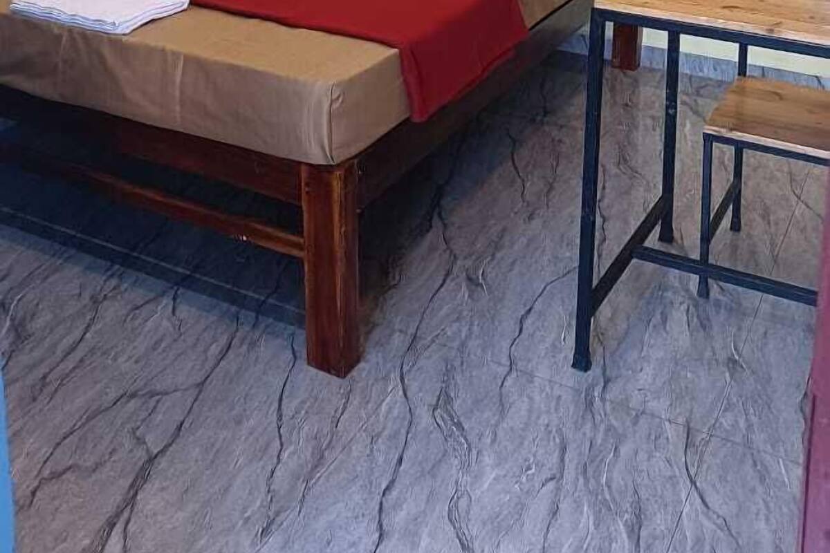 Une chambre à coucher avec un lit, une table en bois et un ventilateur de plafond.
