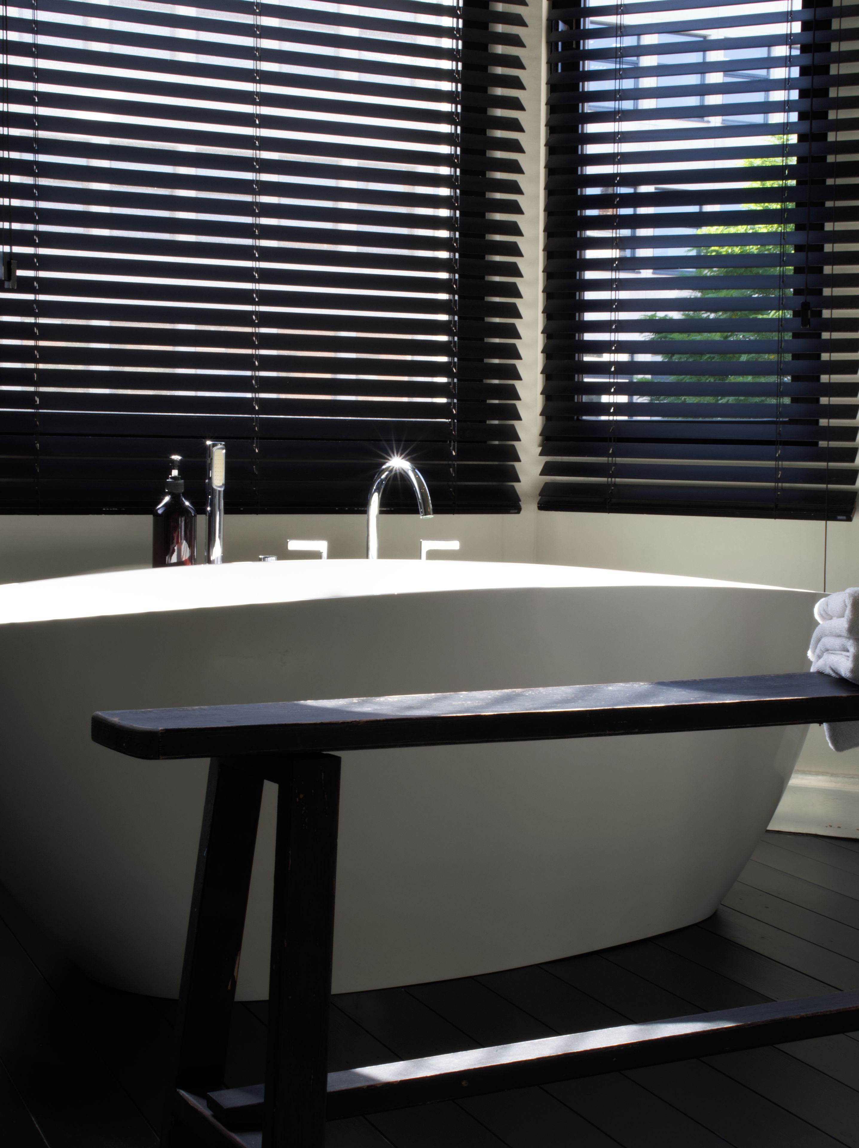 A modern bathroom with a freestanding bathtub, a faucet, and a toilet.