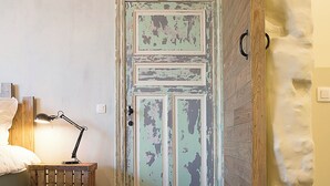 Quarto com cama, luminária de mesa e uma caixa de madeira.