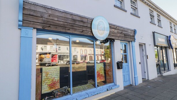 Une devanture de magasin avec un auvent bleu et une enseigne sur laquelle on peut lire : « Christ Within Markethill ».