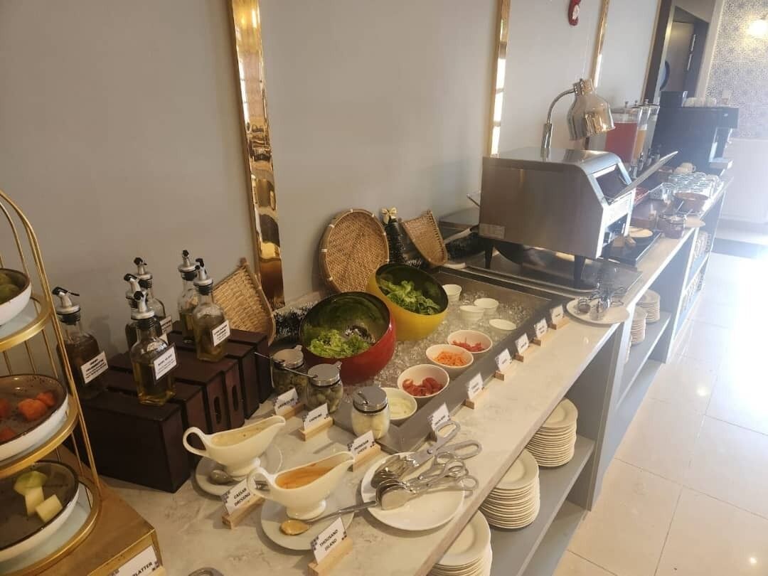 A buffet setup with various food items and condiments.