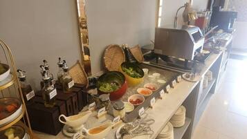 A buffet setup with various food items and condiments.
