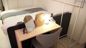 A neatly arranged bedroom with a bed, a desk with a chair, a bedside lamp, and a mirror. - Pyungtaek1981 (Pyeongtaek)