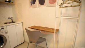 A compact kitchen with a washing machine, a wooden countertop, and a chair. - Pyungtaek1981 (Pyeongtaek)