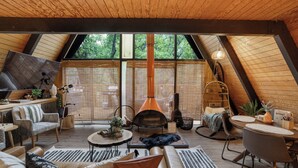 Une pièce confortable de style loft, dotée d’une grande fenêtre, d’une cheminée et de différents types de sièges.