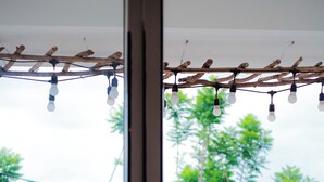 Ein Balkon mit zwei Stühlen, einem Tisch und einer Zierleuchte.