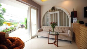Ein modernes Wohnzimmer mit einer Couch, einem Glastisch und einem großen, bogenförmigen Fenster.