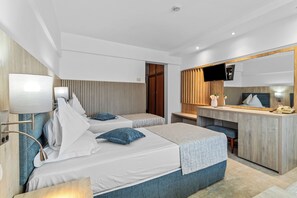 A modern hotel room with two beds, a desk, a TV, and a mirror.