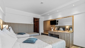 A modern hotel room with two beds, a desk, a mirror, and a television.