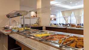 A buffet with various food options including scrambled eggs, bacon, and fried chicken. - Hotel Condor (Constanta)