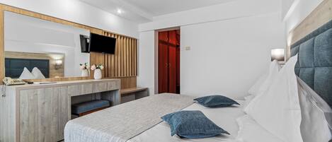 Una habitación de hotel moderna con una cama, un escritorio, un espejo y un televisor.