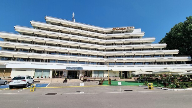 A multi-story hotel with a prominent 'Condor' sign, featuring a modern architectural design with balconies and a central entrance.