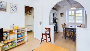 Een kleine woonruimte met een eethoek, keuken en wasruimte.