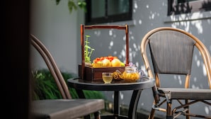 A table with a fruit basket, a glass of drink, and a bottle of oil. - Suzhou Shantang Scholars Boutique Hotel (Suzhou)