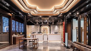 A modern hotel lobby with a reception desk, seating area, and decorative elements. - Suzhou Shantang Scholars Boutique Hotel (Suzhou)