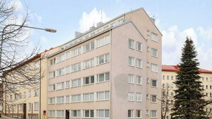 A multi-story building with a flat facade, several windows, and a red roof. - Kotimaailma KotikolmioOikokatu (Lahti)