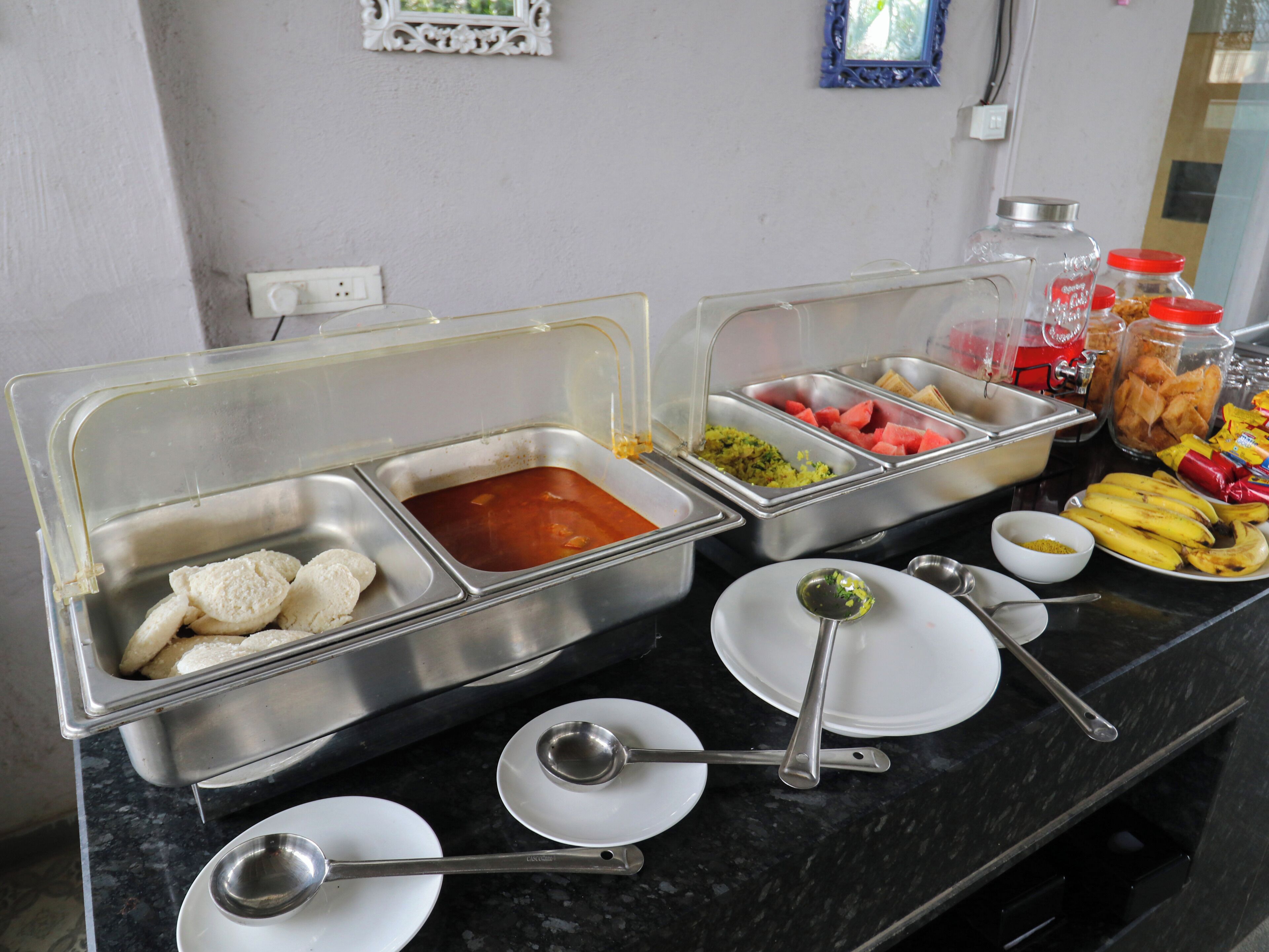 A buffet setup with various food items and serving utensils.