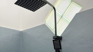 A shower with a square head and a handheld showerhead, mounted on a wall with a corner window. - Alfa Kuta (Kuta)