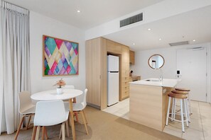 Een moderne keuken met een centraal eiland, houten kastjes en een wit aanrecht.