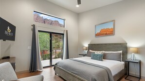 A modern hotel room with a large bed, a desk, and a view of the outdoors. - Moondance @ Oak Creek | Townhouse w/Views| FirePit (Sedona)