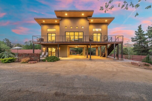 A modern two-story house with a covered patio, large windows, and a staircase leading to the upper level. - NEW|Oak Creek Retreat|Townhouse w/Views|FirePit (Sedona)