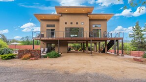 A modern two-story house with a covered patio and a staircase leading to the upper level. - Moondance @ Oak Creek | Townhouse w/Views| FirePit (Sedona)
