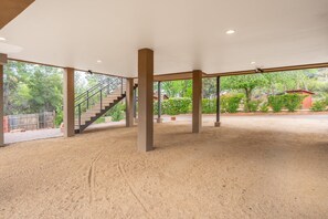 An indoor covered area with a staircase, columns, and a view of greenery outside. - Cimaron Butte View Terrace | 2 Kings | FirePit (Sedona)
