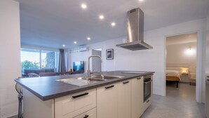 A modern kitchen with a central island, stainless steel appliances, and a built-in oven. - HT RTA Sole Dell'Argentario (Porto Santo Stefano)