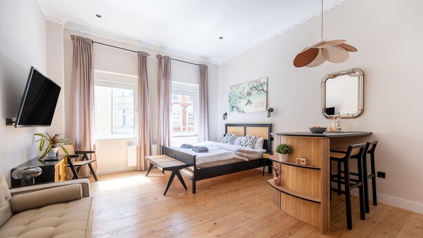 A bedroom with a bed, bedside table, TV, and a desk with chairs. - Apartment in Koblenz near Deutsches Eck (Koblenz)