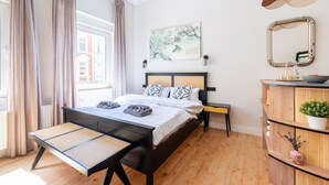 A modern bedroom with a bed, bedside table, and a wooden dresser. - Apartment in Koblenz near Deutsches Eck (Koblenz)